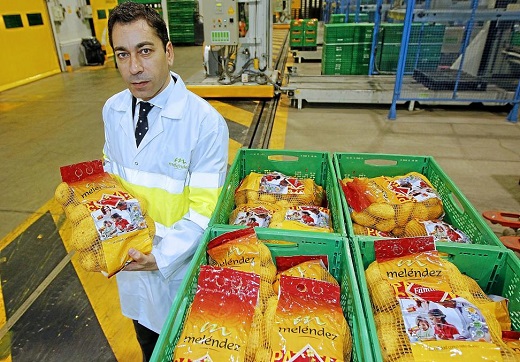 Javier Meléndez, con una de las bolsas de cinco kilos recién salida de la línea de produccion de la fábrica de Patatas Meléndez en Medina del Campo. - J. M. LOSTAU