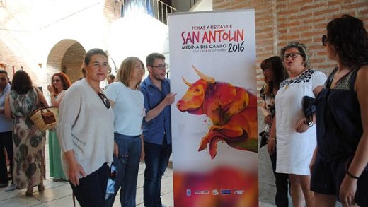 La alcaldesa de Medina, Teresa López, junto al concejal de Festejos, José María Magro, la portavoz del PP, Olga Mohíno, y representantes de las asociaciones de vecinos posan junto al cartel anunciador de las fiestas patronales de San Antolín. / P. González