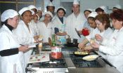 Los quince alumnos observan cómo se cocinan cebollas rellenas alrededor de la cocina. / FRAN JIMÉNEZ