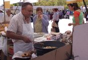 Un confitero fríe las rosquillas en presencia de compradores y curiosos. / F. JIMÉNEZ