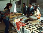 Un grupo de curiosos, en un puesto de la Feria del Libro de Medina. 