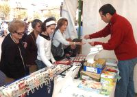 Varias personas visitan uno de los puestos de la feria de Hispanoamérica. / FRAN JIMÉNEZ