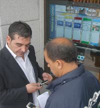 El concejal popular Ramsés Laguna y el socialista Alfredo Losada comprueban con sus móviles el nuevo sistema. / FRAN JIMÉNEZ