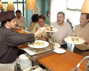 El cocinero del Villa de Ferias de Medina de Campo ofrece los pinchos a unos clientes. / FRAN JIMÉNEZ 