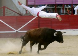 Un recortador efectúa un gran salto en el concurso de cortes de 2008./ F. J. Varios corredores durante el encierro urbano./ F. J.