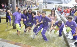 Una peña se refresca en la fuente de la plaza de Segovia.