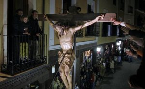 Una mano toca el madero de la cruz durante la procesión de Medina de Rioseco,. :: LUIS LAFORGA