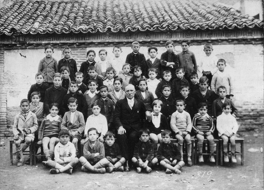 Alumnos de una escuela medinense desconociéndose quien es el profesor pero sí alguno de los medinenses de la familia González, Julio, detrás del profesor, de la fábrica de muebles Hermanos González de Medina del Campo, 1925. 