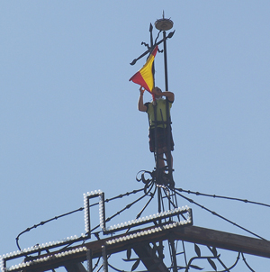 Colocación de la bandera nacional en lo alto de la Colegiata.