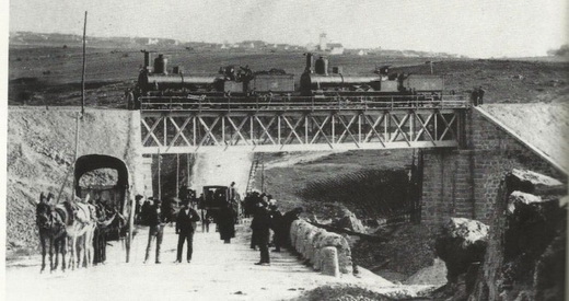 Imagen antigua de un ferrocarril pasando sobre el Puente de Hierro.