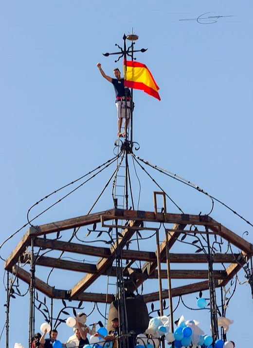 Colocación de la Bandera Nacional en lo alto de la Colocación de la Bandera Nacional en lo alto de la Iglesia Colegiata de San Antolín a cargo de la Peña «BEODOS» Fotografía: Fernando Amigo