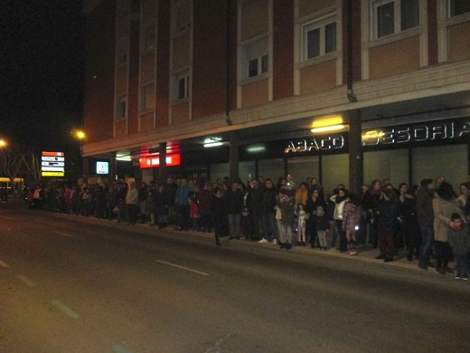 Gente en el recorrido, esperando la procesión, a pesar de las gotas de lluvia caídas y un fuerte viento.