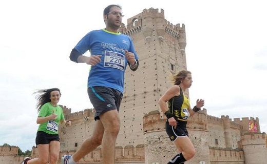 Participantes en una prueba deportiva corren delante del castillo de la Mota de Medina. / FRAN JIMÉNEZ