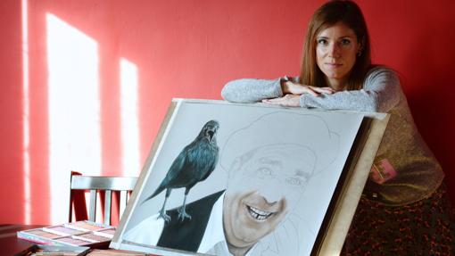 La dibujante y pintora Laura Serrano posa con uno de los cuadros que forman parte de la exposición en la que vecinos de la localidad vallisoletana de Urueña, ponen sus rostros para llevar al lienzo a los prot - EFE/Nacho Gallego