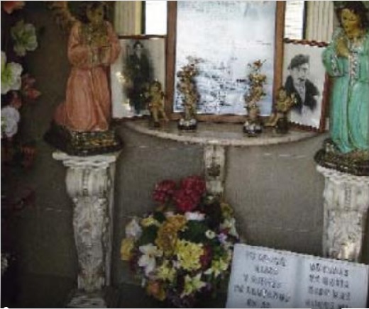 Sepulcro, repleto de flores, ánforas y cirios encendidos puede leerse: "Yace aquí Ramón Ferreruela". 