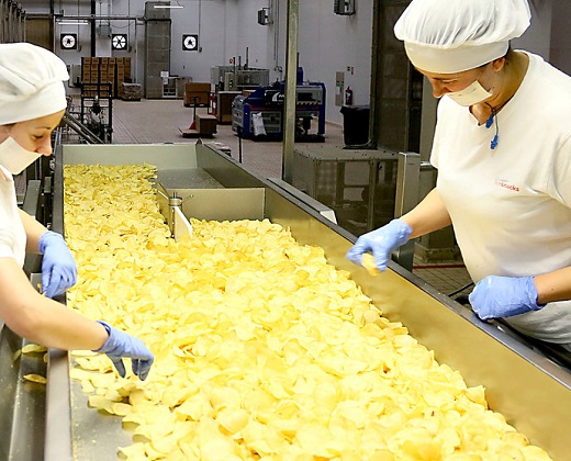 Dos operarias vigilan la calidad de las patatas fritas en las instalaciones de Ibersnacks en Medina del Campo.- ICAL
